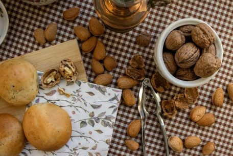 A cozy table with fresh bread, walnuts, and almonds on a checkered cloth, embodying a rustic kitchen vibe.