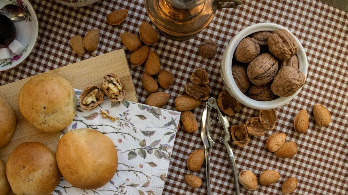 A cozy table with fresh bread, walnuts, and almonds on a checkered cloth, embodying a rustic kitchen vibe.