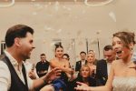 Bride and groom celebrating at a lively indoor wedding reception with friends and family.