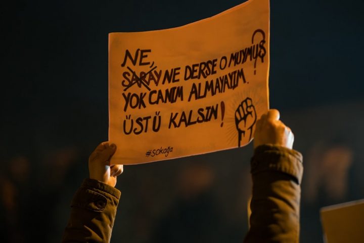 Protester holds sign with turkish text.